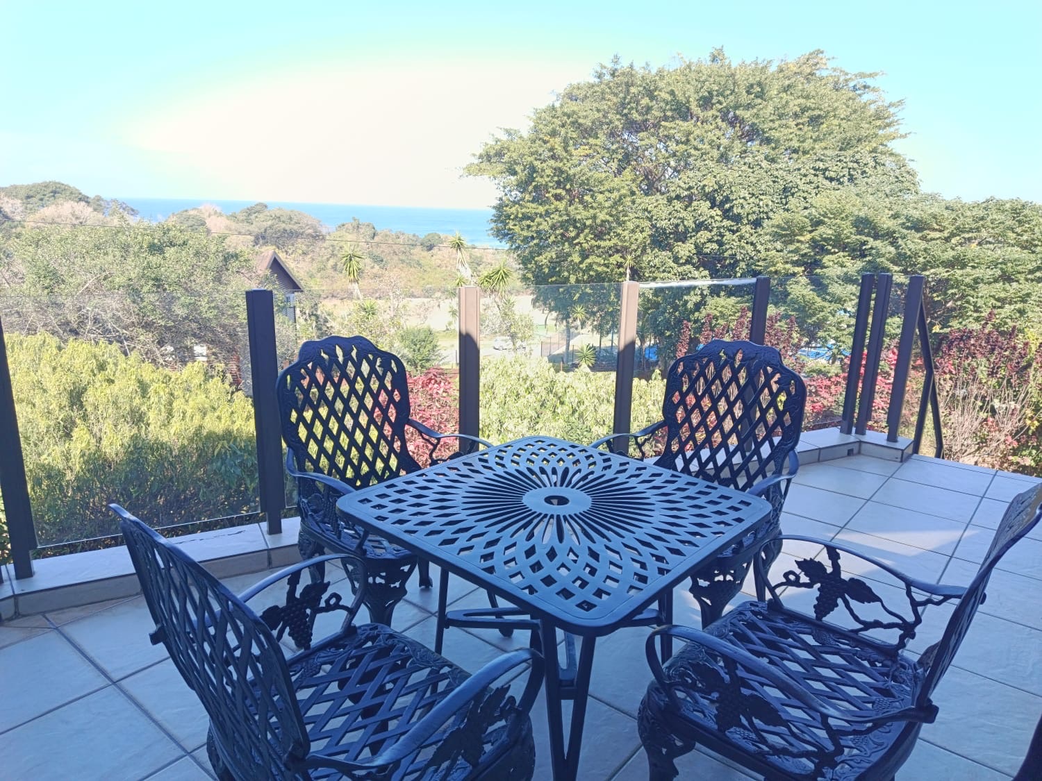 The covered patio at The Tee Box looking out over the garden towards the Indian Ocean